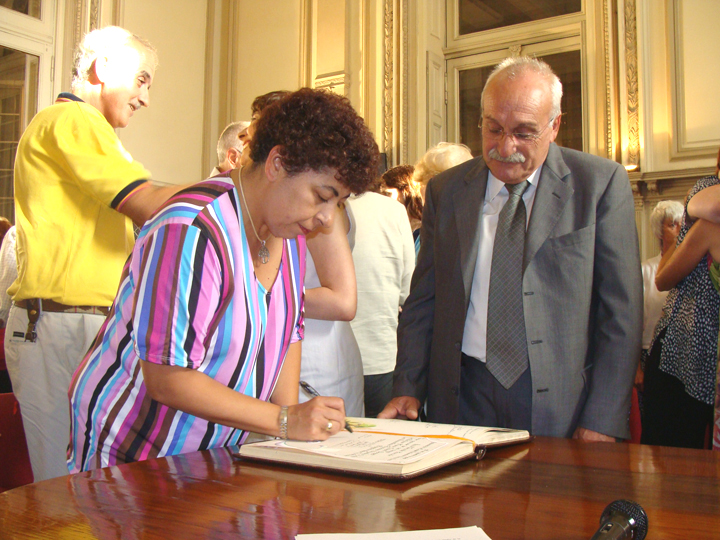 Firma el libro de oro la Vicerrectora  Prof.Alejandra Leoni. A su lado el Dr. Miguel López (Interventor de la Asociación Cooperadora)