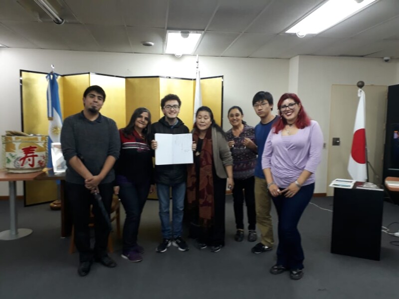 aLUMNOS Y PROFESORA DE JAPOMÉS EN eMBAJADA FIORMADNO EL LIBRO DE BUENOS DESEOS PARA EL NUEVO EMPERADOR DE LA rEIWA